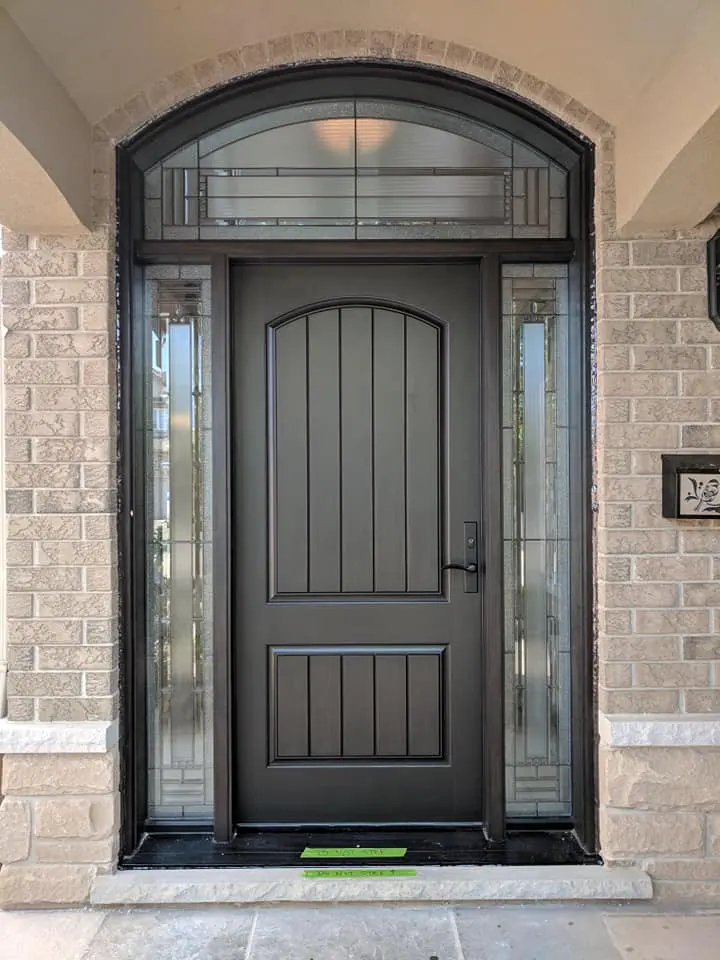 Black entry door with an arched transom and glass sidelites