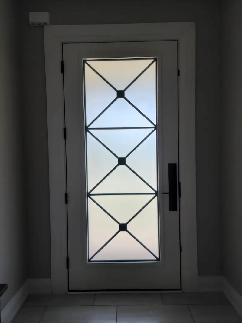 Black fiberglass entry door with a wrought-iron glass insert