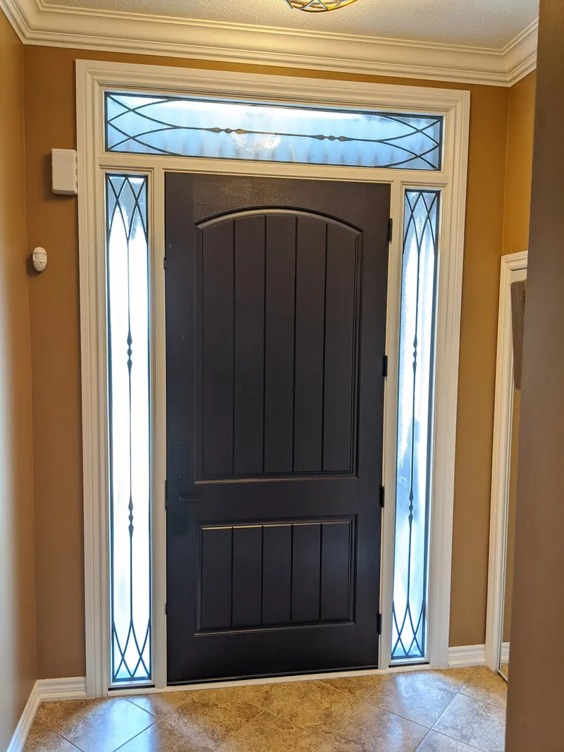 New stained fiberglass front door with an arched transom and decorative glass sidelites