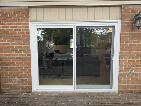 White vinyl sliding patio door in a red brick wall