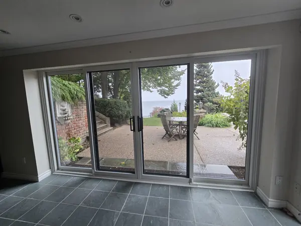White sliding patio door seen from inside, opening onto a stone terrace